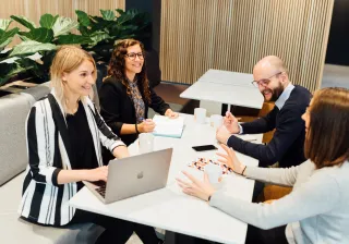 illustrative image of people sitting around a table in an office setting