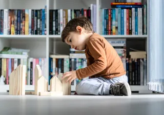 Child building a house from blocks