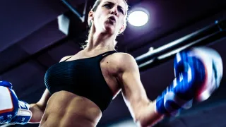 A strong female boxer is throwing a punch