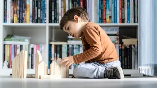 Child building a house from blocks