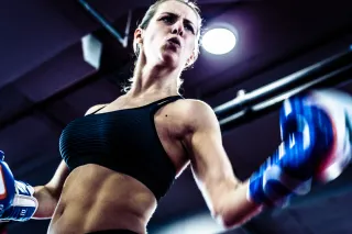 A strong female boxer is throwing a punch