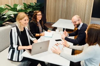 illustrative image of people sitting around a table in an office setting