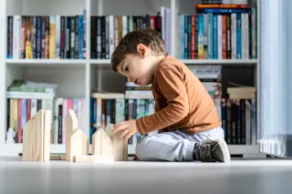 Child building a house from blocks